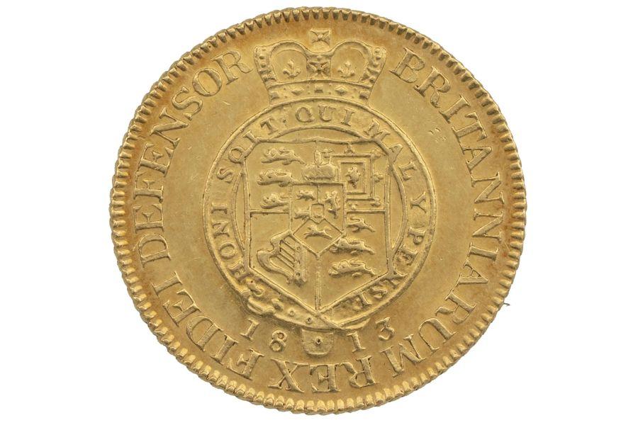 Sshield of royal arms surrounded by a crowned garter with the date below (1813) and a legend around which reads 'BRITANNIARUM REX FIDEI DEFENSOR'.